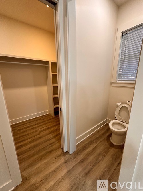 A room with a white door and a wooden floor.