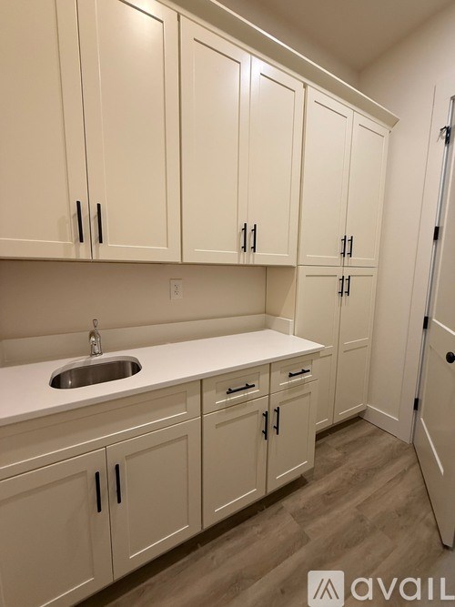 A kitchen with white cabinets and a sink.