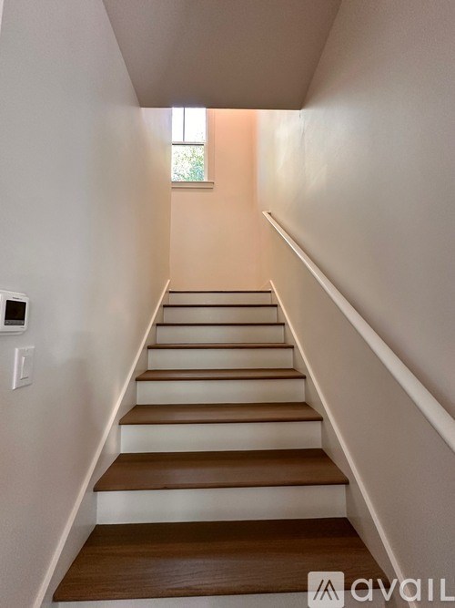 A staircase with white walls and wooden steps.