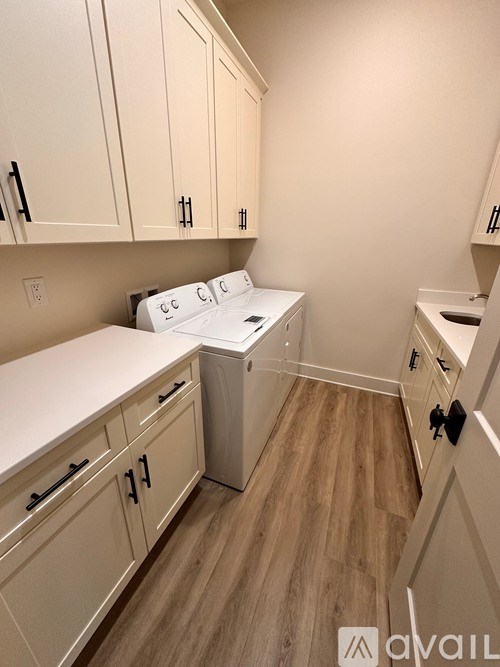 A kitchen with white cabinets and a washer and dryer.