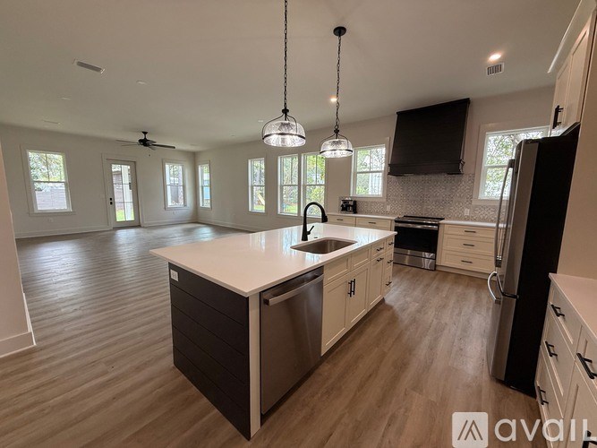 A kitchen with a large island and wooden floors.