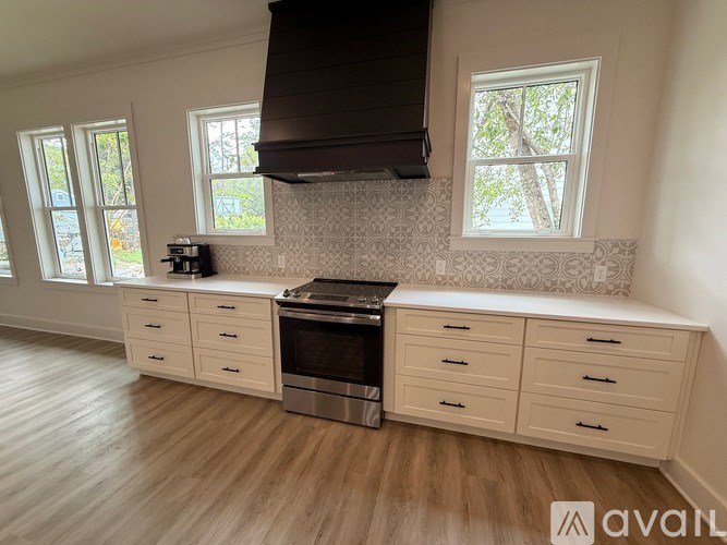 A kitchen with wooden floors and a stove top oven.