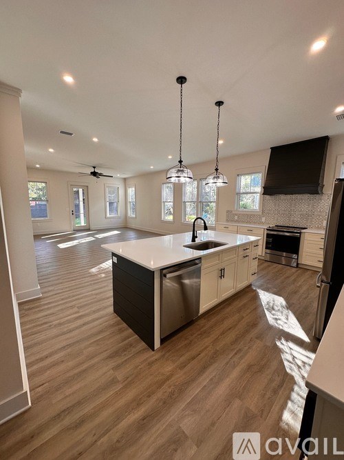 A spacious room with wooden flooring and a ceiling fan.