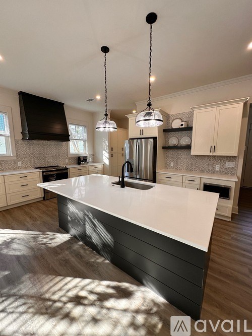 A hallway with wood flooring and white walls.