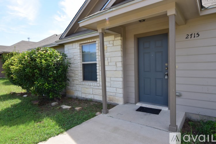 A house numbered 2115 with a blue door and a window.