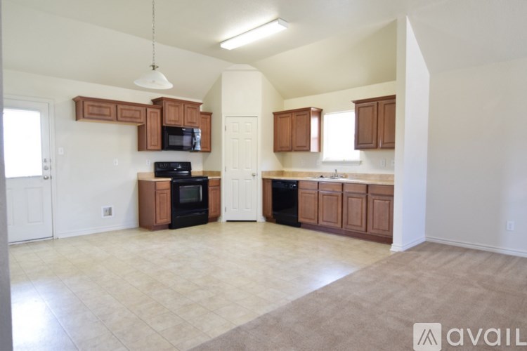 A kitchen with brown cabinets and a black stove top oven.