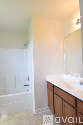 A bathroom with a white tub and sink.