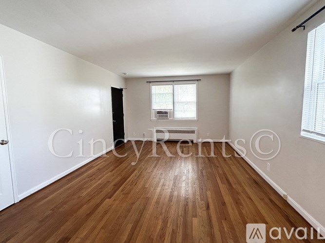A room with wooden flooring and a window with blinds.