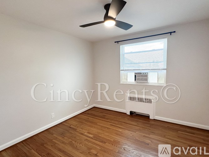 A room with a ceiling fan and wooden flooring.