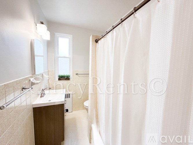 A bathroom with a white shower curtain and a white sink.