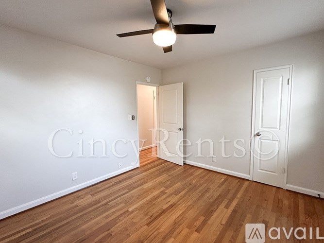 A room with a ceiling fan and wooden flooring.