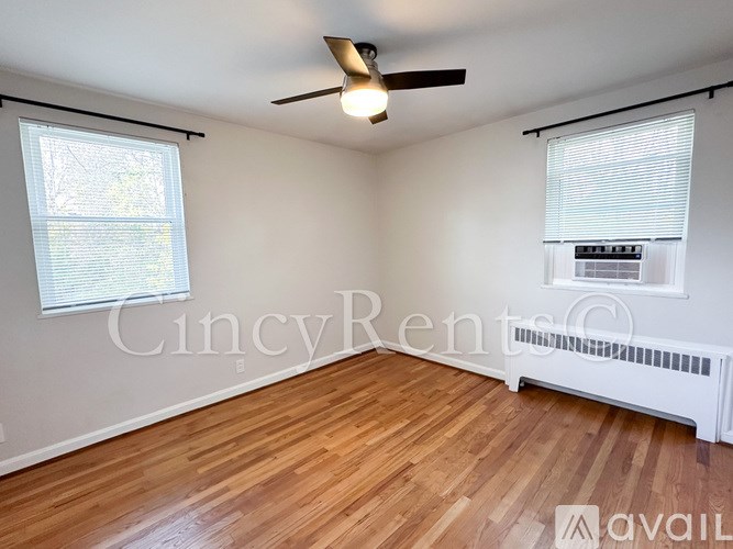 A room with a ceiling fan and wooden flooring.