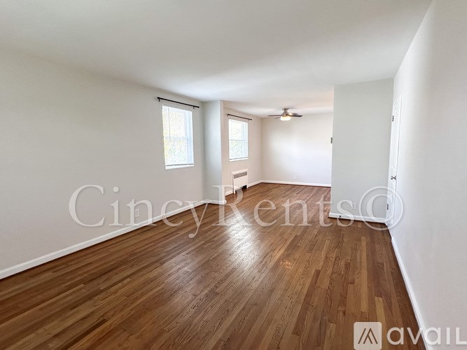 A room with wooden flooring and a window with blinds.