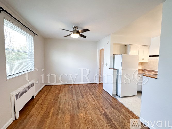 A room with a ceiling fan and wooden flooring.