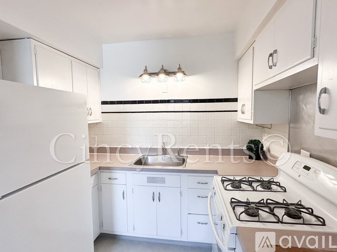 A kitchen with white cabinets and a white gas stove.