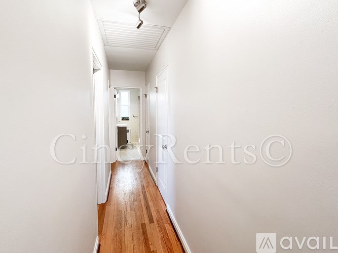 A long hallway with wooden floors and white walls.