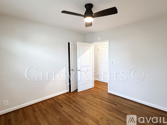 A room with a ceiling fan and a doorway leading to another room.