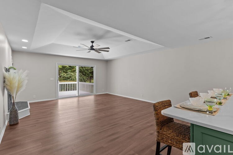 A dining room with a table set for two and a fan on the ceiling.