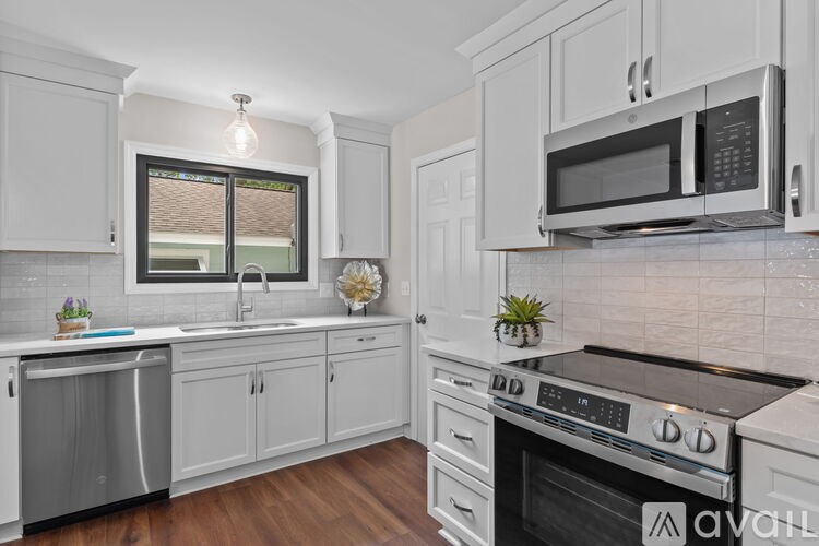 A kitchen with white cabinets and appliances.