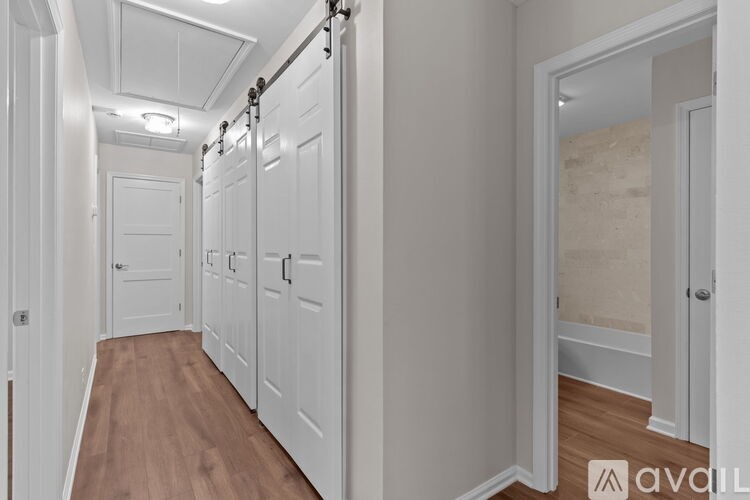 A hallway with white doors and a wooden floor.