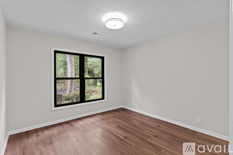 A room with a window showing a tree outside.