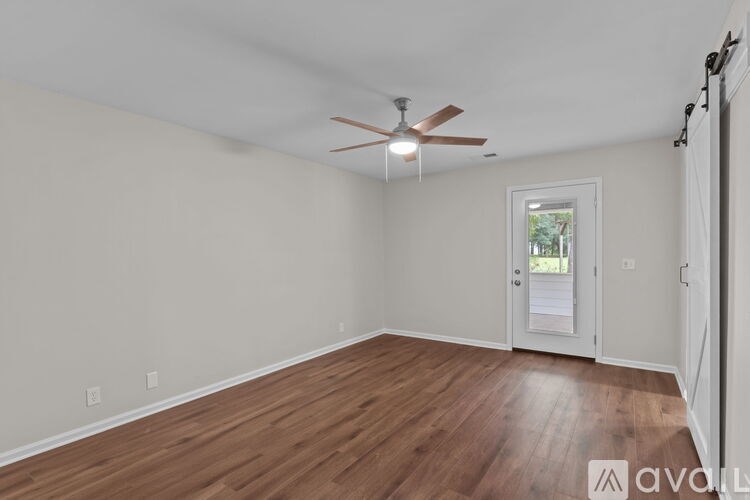A room with wooden floors and a ceiling fan.