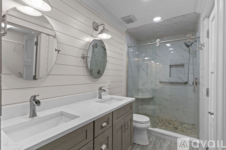 A bathroom with a marble countertop and a walk-in shower.