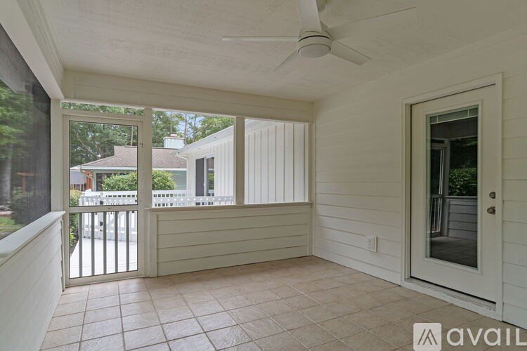 A balcony with a fan and sliding glass doors.