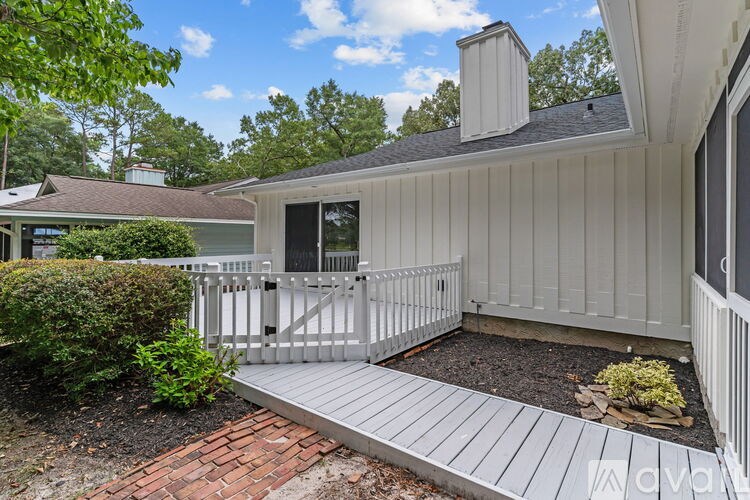 A house with a white fence and a grey roof.
