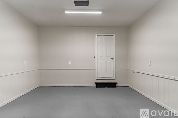 A room with a white door and a light on the ceiling.