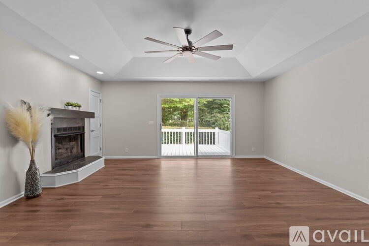 A spacious room with a fireplace and a ceiling fan.