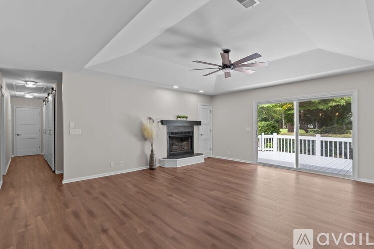 A living room with a fireplace and a ceiling fan.