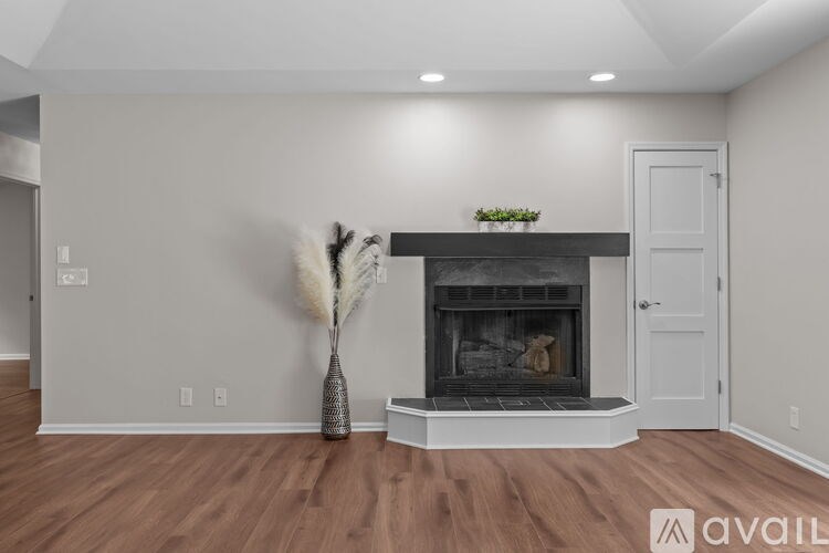 A modern living room with a fireplace and a vase with white feathers.