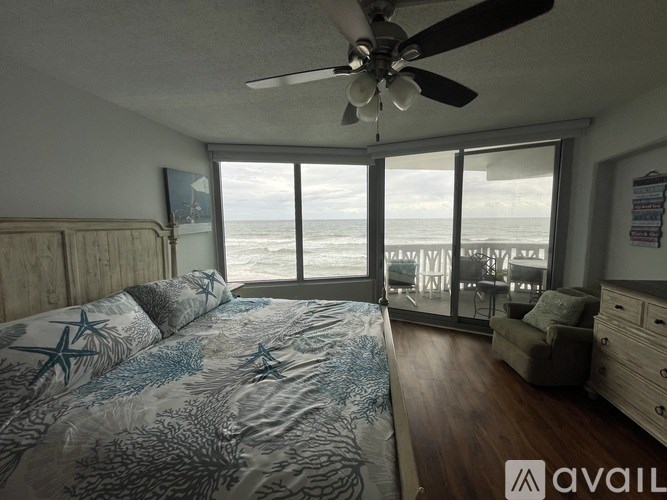 A bedroom with a large bed and a view of the ocean.