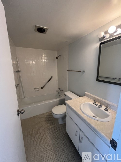 A bathroom with a toilet, sink, and shower.