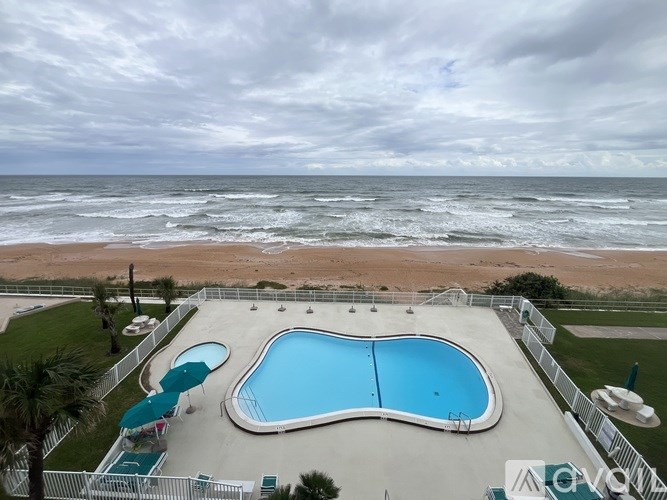 A large outdoor swimming pool with a smaller one attached to it.