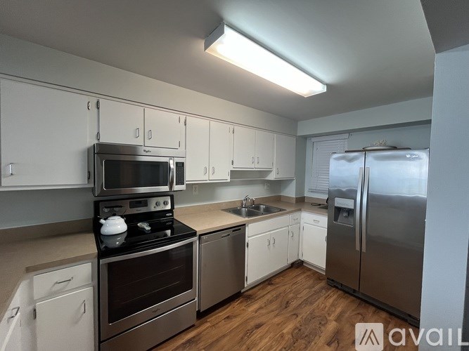 A kitchen with white cabinets and stainless steel appliances.