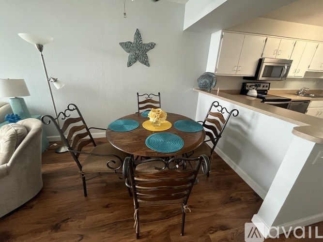 A kitchen with a table set for four with blue plates.