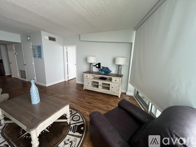A living room with a brown leather couch and a wooden coffee table.