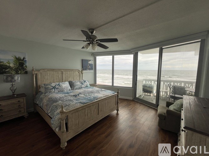 A bedroom with a large bed and a ceiling fan.