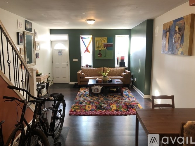 A living room with a couch, a coffee table, and a bicycle.