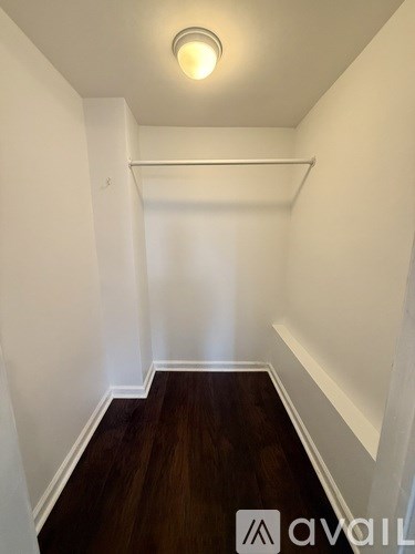 A room with a bed, a chair, and a fan.