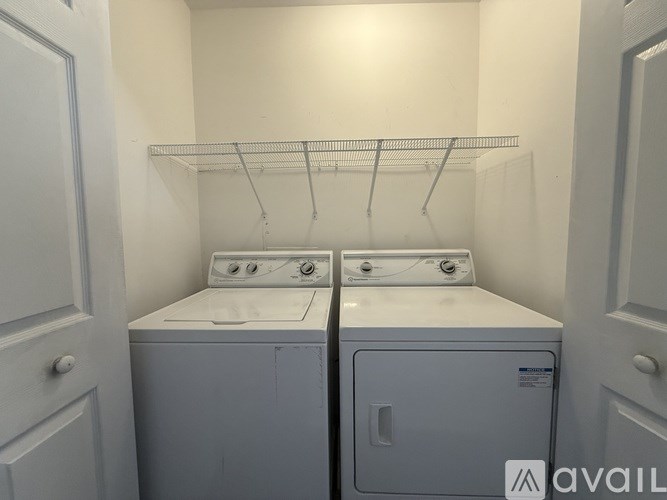 A room with a rug and two windows.