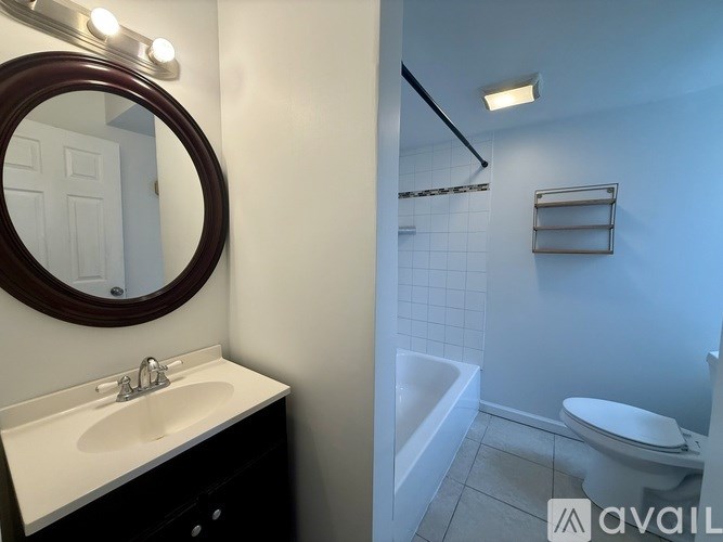 A bathroom with a black mat on the floor.