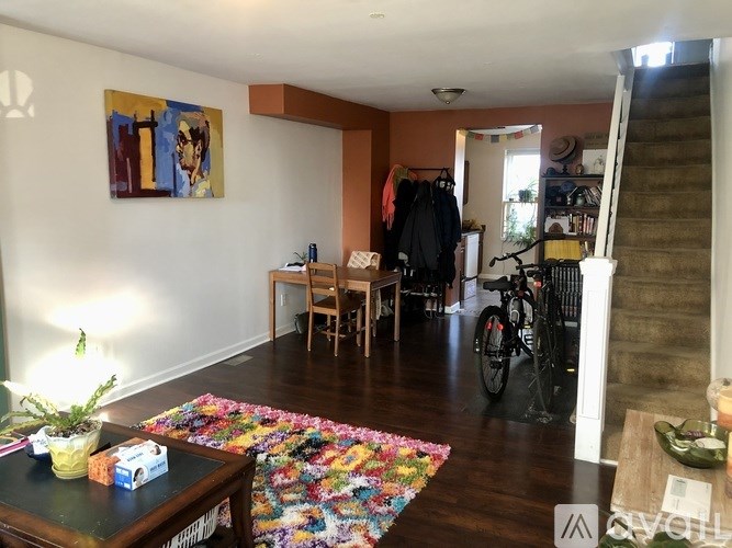 A living room with a colorful rug on the floor.