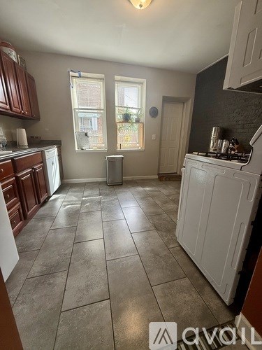 A kitchen with a white stove top oven and brown cabinets.
