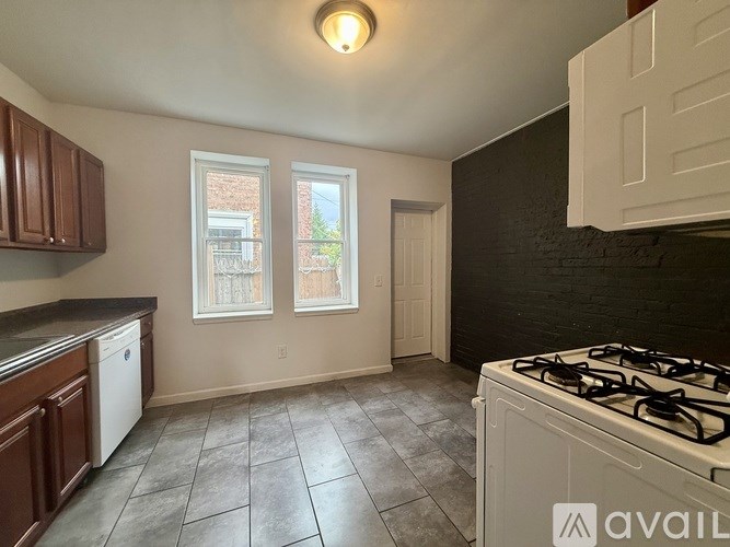 A backyard with a wooden fence, a planter box, and a table.