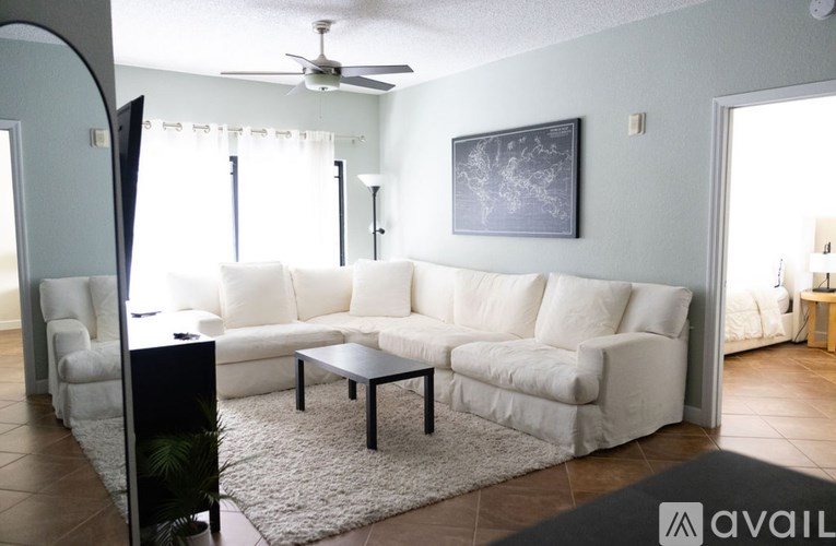 A living room with a white couch and a black coffee table.