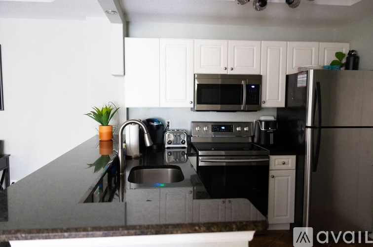 A kitchen with a black countertop and white cabinets.