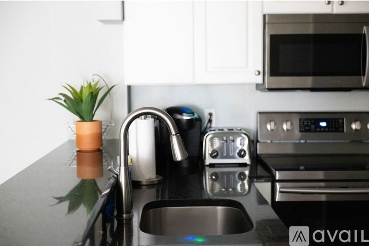 A modern kitchen with a stainless steel sink and oven.